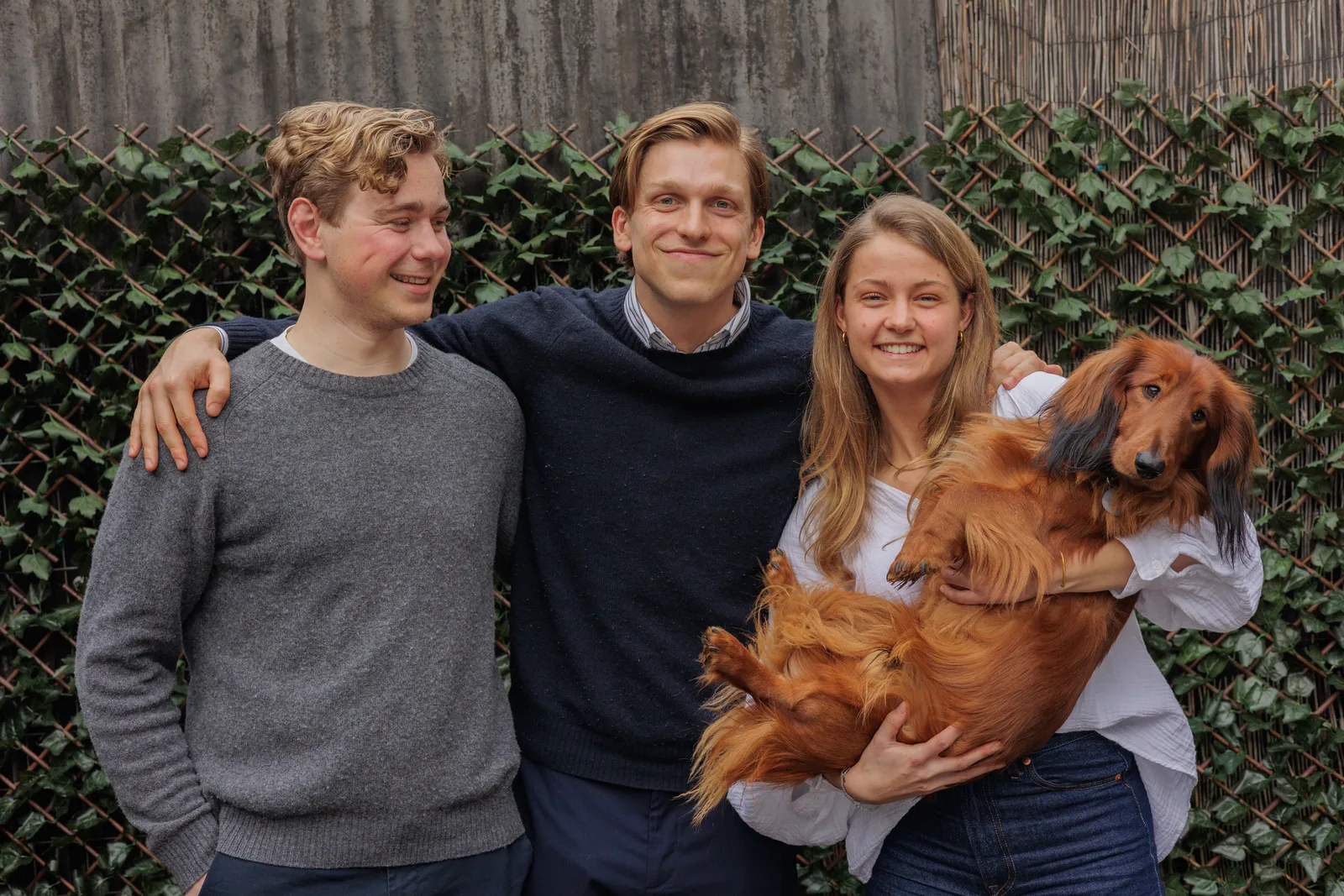 Drie collega's van CribConnects AI met de kantoorhond