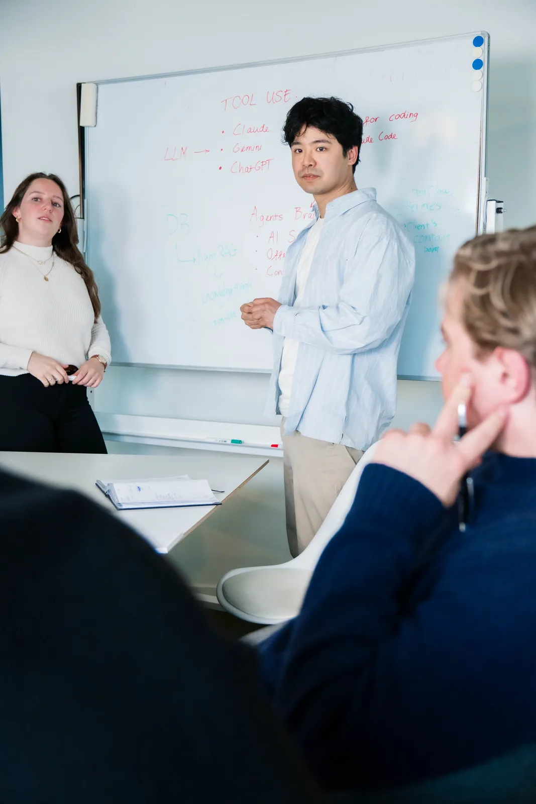 Twee trainers van CribConnects AI voor het whiteboard tijdens een tool-use-sessie
